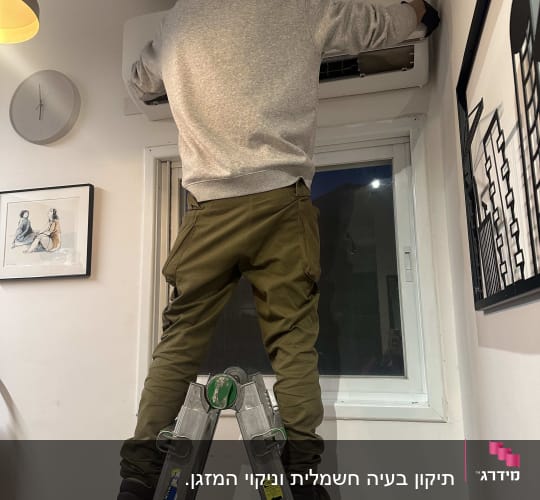 אדם על סולם מתקין מזגן על קיר